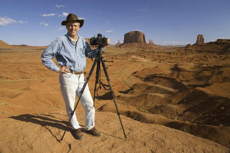 Professional photographer with camera on tripod posing in Monument Valley, Southern Utahのeditorial素材