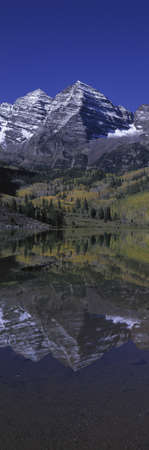 Panoramic view of autumn colors of Aspens reflecting in lake under Maroon Bells, Colorado, near Aspenのeditorial素材