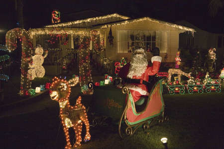 Santa Claus waving in front of house with Christmas lights in Oxnard, Californiaのeditorial素材
