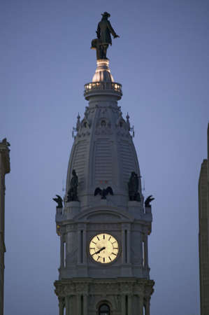 William Penn statue and clock on the top of City Hall at dusk from Broad Street, Philadelphia,...