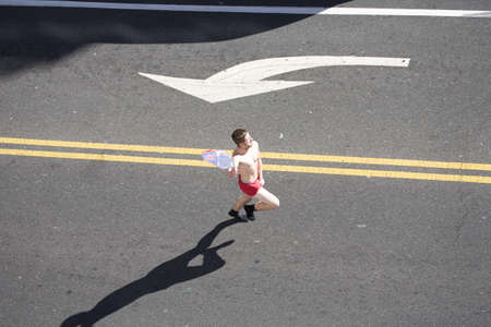 Single runner runs in red shorts running and celebrating Phillies World Series victory October 31, 2008 with parade down Broad Street Philadelphia, PAのeditorial素材