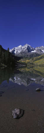 Panoramic view of autumn colors of Aspens reflecting in lake under Maroon Bells, Colorado, near Aspenのeditorial素材