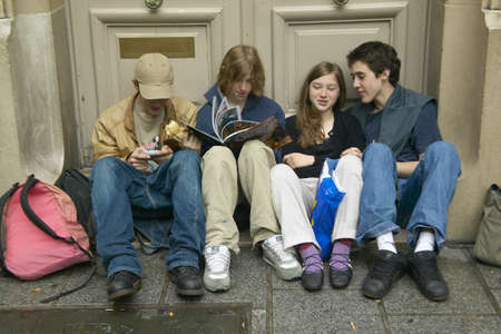 Teenagers sitting in doorway after school, Paris, France