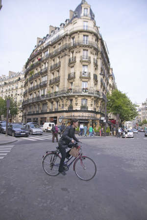 Woman crossing street on bicycle, Paris, Franceのeditorial素材