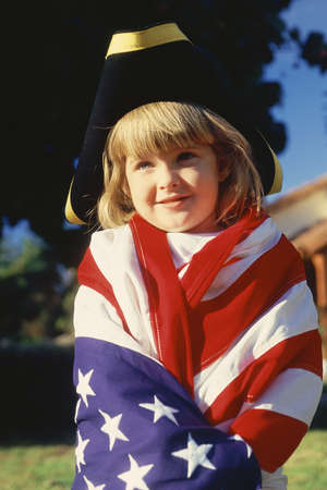 Little girl wrapped in American flag wearing three cornered hat のeditorial素材