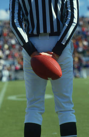 Referee holding a football behind his back, West Point, New York