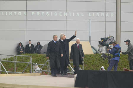 Former U.S. President Bill Clinton waves from the stage accompanied by President George W. Bush, former presidents Jimmy Carter and George H. W. Bush during the official opening ceremony of the Clinton Presidential Library November 18, 2004 in Little Rockのeditorial素材