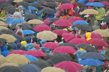 Guests hold umbrellas in the rain as they attend the official opening ceremony of the Clinton...