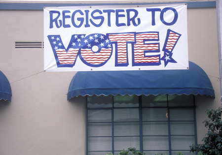 Large hand painted sign reads Register to Vote, CA