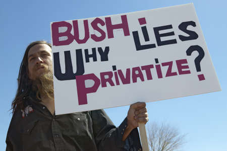 Protestor in Tucson Arizona of President George W. Bush holding a sign protesting his Iraq foreign policy のeditorial素材
