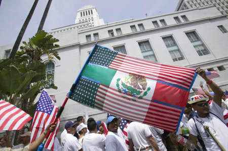 Mexican flag is superimposed over American flag in front of City Hall, Los Angeles, while hundreds...