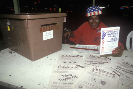 Election volunteer and ballot box in a polling place, CA