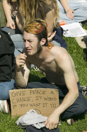 A hippy has "Give Peace A Chance" slogan on his protest sign at an anti-Iraq War protest march in Santa Barbara, California on March 17, 2007のeditorial素材