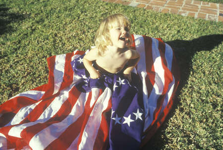 Little Girl Wrapped in American Flag, United States                                    のeditorial素材