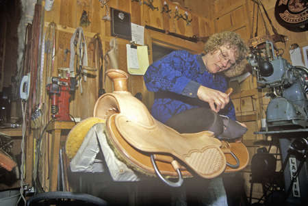 Women works on saddle at Three Forks Custom Saddlery, MT