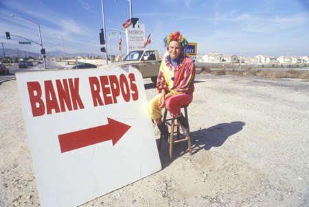 Clown salesperson with Bank Repo sign at roadside dealershipのeditorial素材