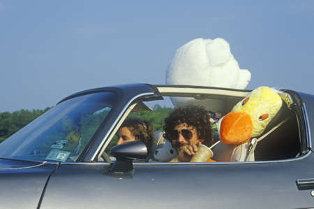 Driver with aviator sunglasses and stuffed animals in TransAm on New Jersey Turnpike
