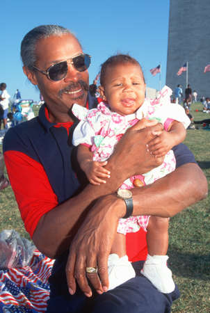 African-American man holding his granddaughter at the Washington National Monument, Washington D.C.のeditorial素材