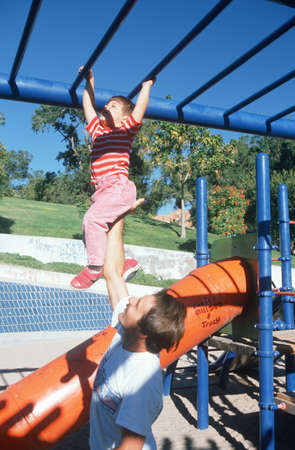A father and daughter playing on the jungle gym, Albequerque, NM