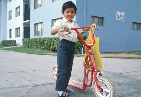 A Mexican-American boy with his scooter, East Los Angeles, CAのeditorial素材