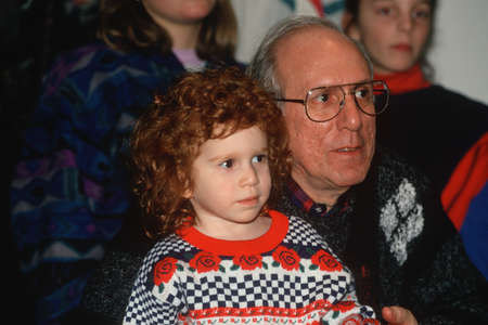 A girl and her grandfather watching children's theatre, Chicago, ILのeditorial素材