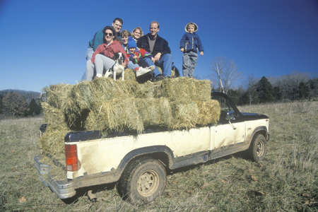 A family sitting on hay bales, Bourbon,MOのeditorial素材