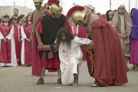 Roman soldiers overseeing reenactment of Jesus Christ carrying a cross on Good Friday, Easter,...