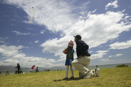 A father and his young daughter flying a kite in a deep blue sky on April 15, 2007, at the Santa Barbara Kite Festival, Santa Barbara City College, overlooking Pacific Ocean.のeditorial素材