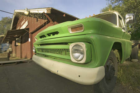 Bright green 1950's truck parked in front of red barn in Oak View, California.のeditorial素材