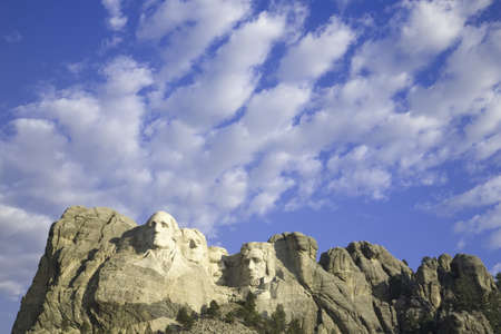 White puffy clouds behind Presidents George Washington, Thomas Jefferson, Teddy Roosevelt and Abraham Lincoln at Mount Rushmore National Memorial, South Dakotaのeditorial素材