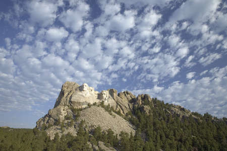 White puffy clouds behind Presidents George Washington, Thomas Jefferson, Teddy Roosevelt and Abraham Lincoln at Mount Rushmore National Memorial, South Dakotaのeditorial素材