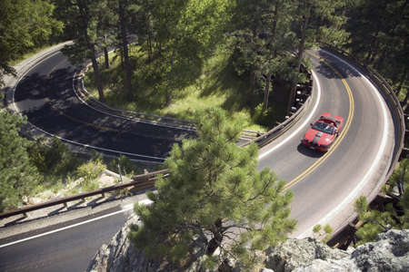 Red convertible driving on Iron Mountain Road, Black Hills, near Mount Rushmore National Memorial,...