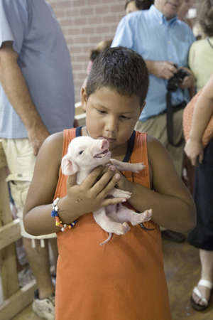 Latino boy holding baby pig at Iowa State Fair, Des Moines, Iowa, August, 2007のeditorial素材