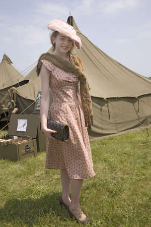 World War II young woman poses in front of army tents wearing Eleanor Roosevelt fox fur around her...