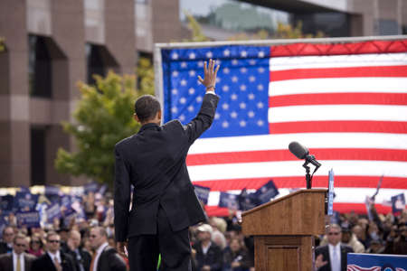 Presidential Candidate Barack Obama waves to crowd as he is framed against American Flag at early vote for change Presidential rally, October 29, 2008 at Halifax Mall, Government Complex in Raleigh, NCのeditorial素材