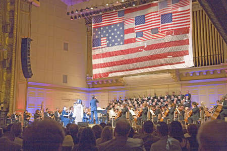 9/11 flag hangs over Keith Lockhart as he conducts the Boston Pops at Symphony Concert Hall, Boston, Ma., USAのeditorial素材