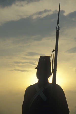 Silhouette of soldier at sunset with gun during reenactment of Battle of Manassas marking the beginning of the Civil Warのeditorial素材