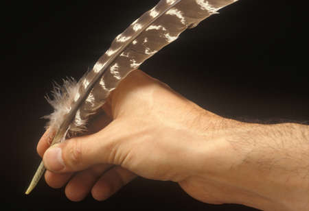 Hand holding quill pen, such as the once used for signing Declaration of Independenceのeditorial素材