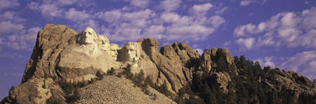 Panoramic image with white puffy clouds behind Presidents George Washington, Thomas Jefferson, Teddy Roosevelt and Abraham Lincoln at Mount Rushmore National Memorial, South Dakotaのeditorial素材