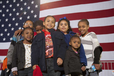A group of young children in front of a flag of the United States of America at a Presidential Campaign rally during the 2012 Presidential Electionのeditorial素材