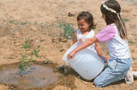 Children watering a sapling on Earth Dayのeditorial素材