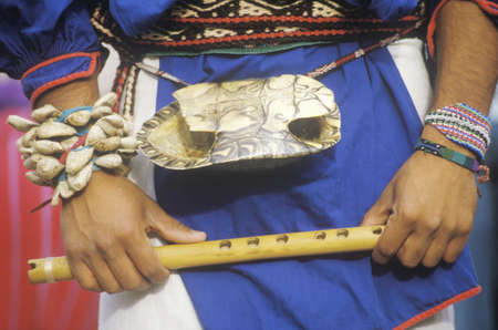 Close-up of turtle shell worn on the waist of a man holding flute during Corn Dance ceremony  in Santa Clara Pueblo, NMのeditorial素材