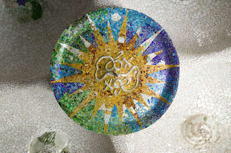 Colored wheel mosaic of colored ceramic tile by Antoni Gaudi at his Parc Guell, Barcelona, Spain