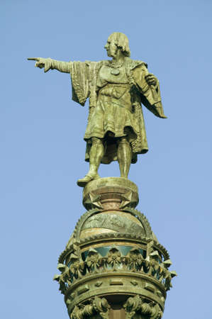 Statue of Christopher Columbus points west to New World, next to waterfront of Port Vell, Barcelona,...