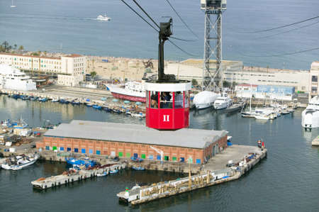 Red tram of tourists look at view of Estacio Maritima, Port Vell the (Old Harbour) of Barcelona, Spainのeditorial素材