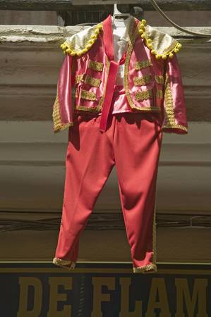 Red toreador bull fighting outfit for boy hangs in Centro old district of Sevilla Spainのeditorial素材