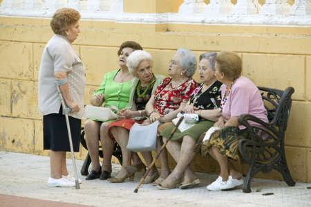 Older women with canes talk on bench in village of Southern Spain off highway A49 west of Sevillaのeditorial素材