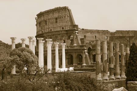 Sepia image of columns of the Forum and Colosseum or Roman Coliseum at dusk with streaked car lights, originally the Flavian Amphitheatre, an elliptical amphitheatre in the centre of the city of Rome, the largest ever built in the Roman Empire, Rome, Italのeditorial素材