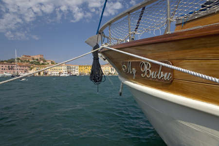 Boat in blue waters of Portoferraio, Province of Livorno, on the island of Elba in the Tuscan Archipelago of Italy, Europe, where Napoleon Bonaparte was exiled in 1814のeditorial素材