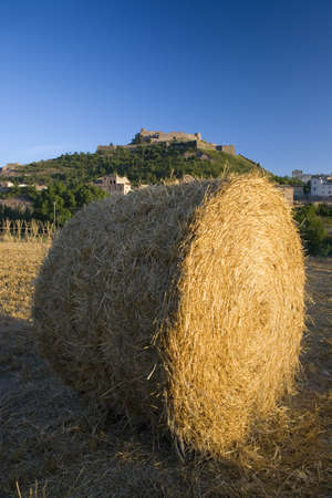 Hay bails in foreground with background of Parador de Cardona, a 9th Century medieval hillside Castle, near Barcelona, Catalonia, Cardona, Spainのeditorial素材